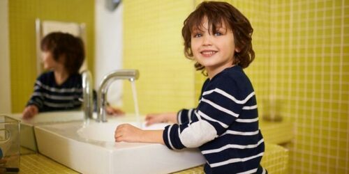 chłopiec myje ręce w przedszkolu